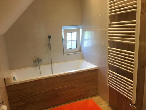 a bathroom with a bath tub and a window at Penzion Olga in Mariánské Lázně