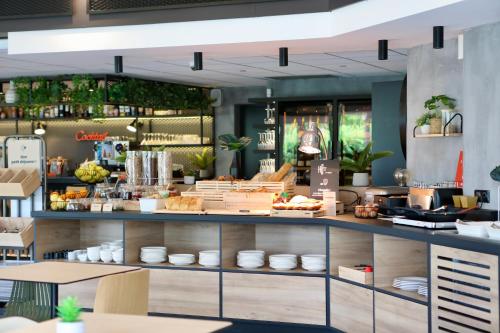 a restaurant with a counter with food on it at ibis Aubenas in Aubenas