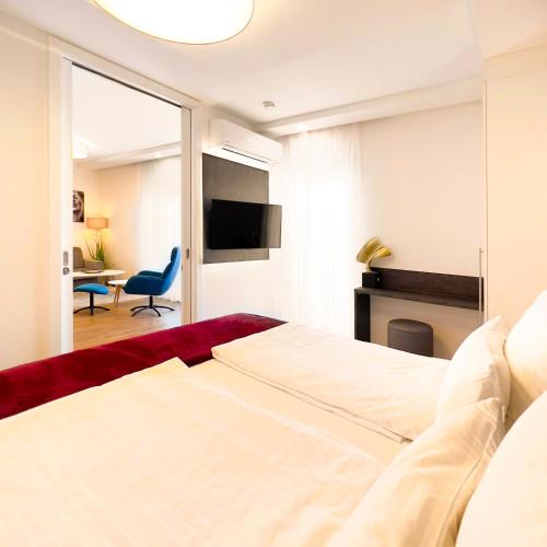a bedroom with a bed and a tv and a desk at VIVA Apartments in Graz