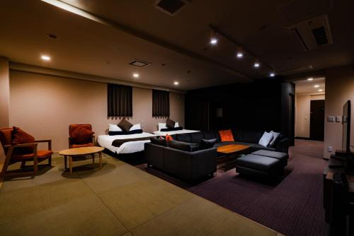 a hotel room with a bed and a couch at Randor Residence Susukino Suites in Sapporo