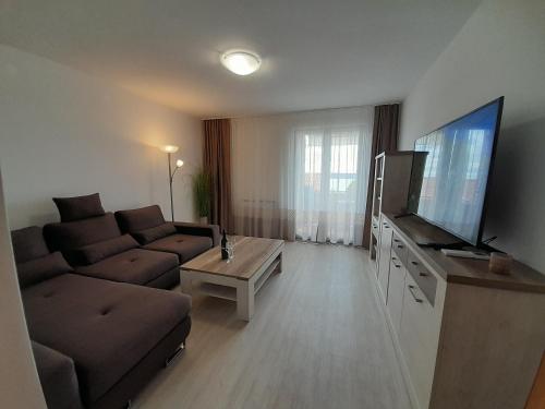 a living room with a couch and a flat screen tv at Apartments Portoroz - Beautiful Street in Portorož