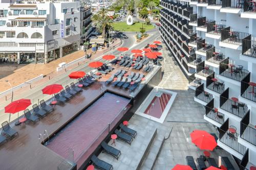 uma vista superior de uma piscina com mesas e guarda-sóis em Hotel Vibra District - Adults Only em San Antonio