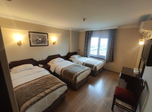 a hotel room with two beds and a window at Hotel Akyildiz in Istanbul