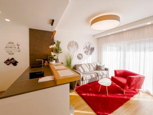a kitchen and living room with a red chair at VIVA Apartments in Graz