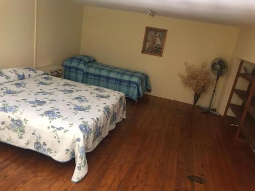 1 dormitorio con 2 camas y suelo de madera en Sicilia confort, en Castellana Sicula