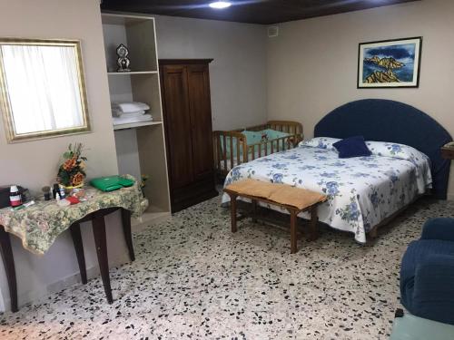 1 dormitorio con cama, mesa y cuna en Sicilia confort, en Castellana Sicula