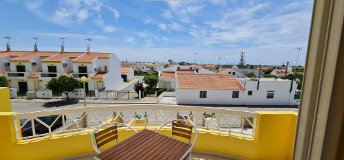 a balcony with two chairs and a view of a city at Manta Treasure - Beach+WiFi+Barbecue+Backyard in Vila Nova De Cacela