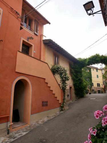 an orange building with a staircase next to a street at La Bella di Lajatico in Laiatico