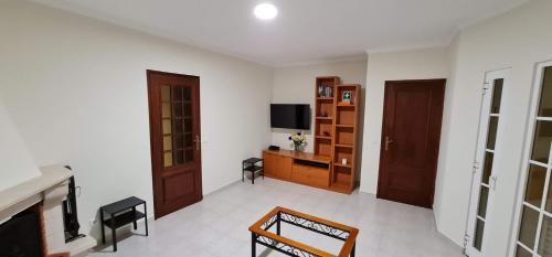 a living room with a fireplace and a television at Manta Treasure - Beach+WiFi+Barbecue+Backyard in Vila Nova De Cacela