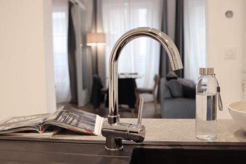 - un lavabo avec robinet et une bouteille d'eau dans l'établissement Le Mans Hypercentre - proche place République, au Mans