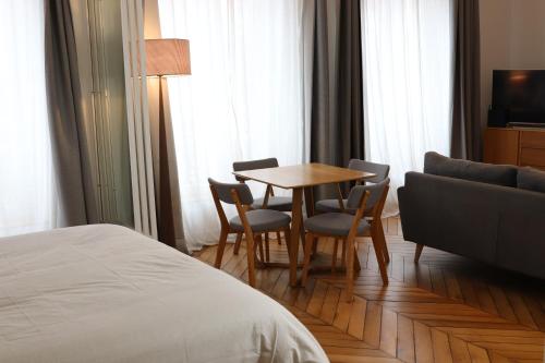 une chambre d'hôtel avec une table, des chaises et un lit dans l'établissement Le Mans Hypercentre - proche place République, au Mans