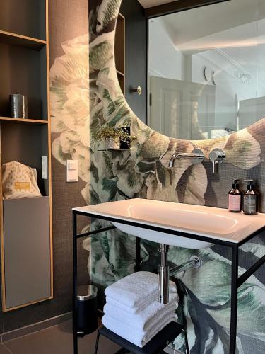 a bathroom with a sink and a large mirror at WELL Pretty Places - sustainable interior design in the Citycenter in Kassel