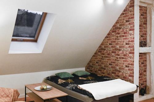 a bed in a room with a brick wall at Kryształowa 47/7 in Piechowice