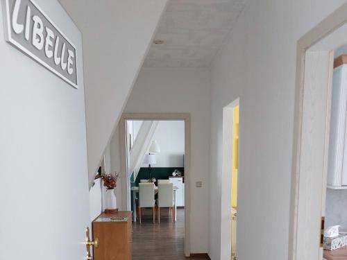 un couloir aux murs blancs et une salle à manger dans l'établissement Spreewald Unterkünfte "alte Zigarrenfabrik" Familie Häfner, à Lübben
