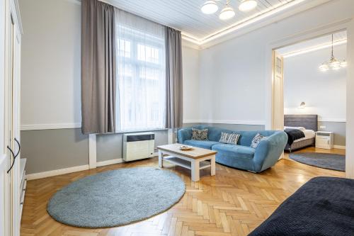 Una sala de estar con un sofá azul y una mesa. en Luxurious Apartments At City Center, en Budapest