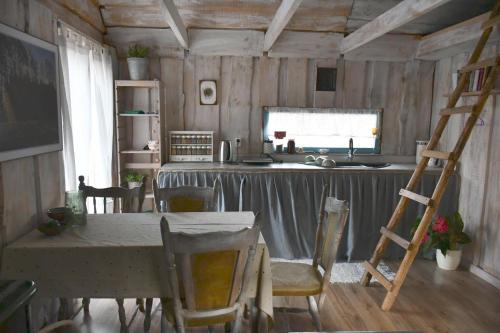 a kitchen with a table and a kitchen with a ladder at Sowia Chatka in Glaznoty