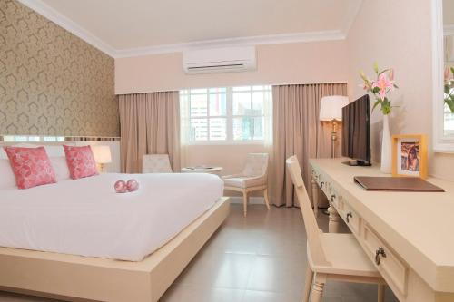 Habitación de hotel con cama y escritorio en The Raya Surawong Bangkok, en Bangkok