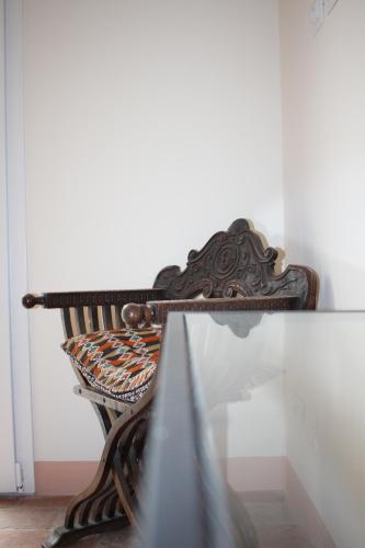 a wooden bench sitting next to a wall at Pioppi Neri R&B in Felino