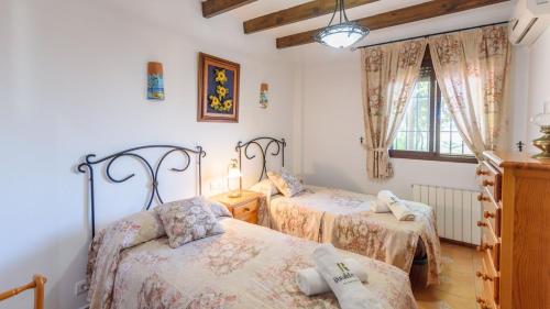1 Schlafzimmer mit 2 Betten und einem Fenster in der Unterkunft Casa La Fajara 2 Canillas de Aceituno by Ruralidays in Canillas de Aceituno