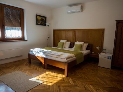 Mamutfenyő Panzió في تاتا: غرفة نوم مع سرير مع لوح خشبي للرأس