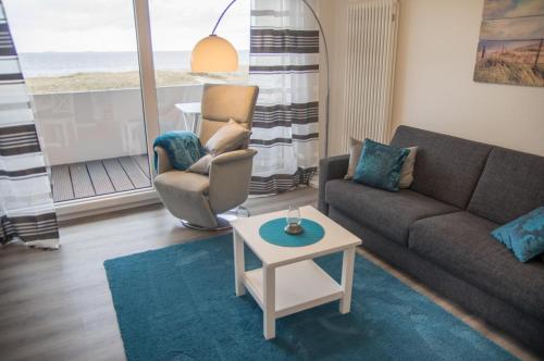 a living room with a couch and chairs and a table at Am Sahlenburger Strand 04 in Cuxhaven