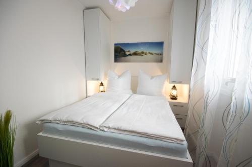 クックスハーフェンにあるAm Sahlenburger Strand 04の白いベッドルーム(白い枕の白いベッド付)