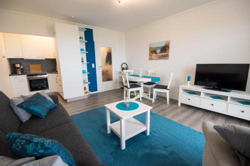 a living room with a couch and a table at Am Sahlenburger Strand 04 in Cuxhaven
