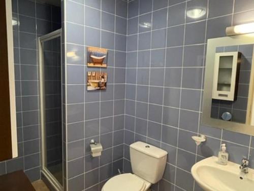 La salle de bains est pourvue de carrelage bleu, de toilettes et d'un lavabo. dans l'établissement Appartement Vieux-Boucau-les-Bains, 2 pièces, 6 personnes - FR-1-379-146, à Vieux-Boucau-les-Bains