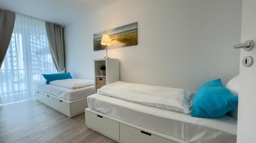 a small bedroom with two beds and a window at Ferienwohnung Nordseebrandung B3.1 in Sahlenburg