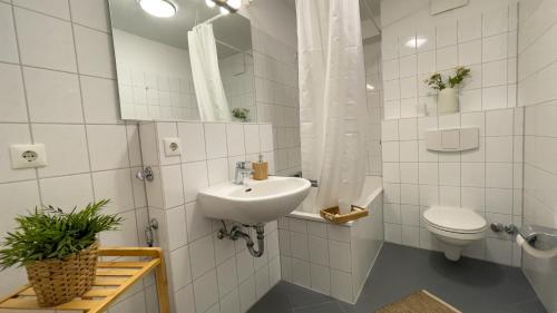 ein weißes Bad mit einem Waschbecken und einem WC in der Unterkunft Ferienwohnung Nordseebrandung A3.3 in Sahlenburg