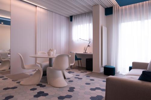 a living room with a table and chairs at Hotel Du Lac - Relax Attitude Hotel in Brenzone sul Garda