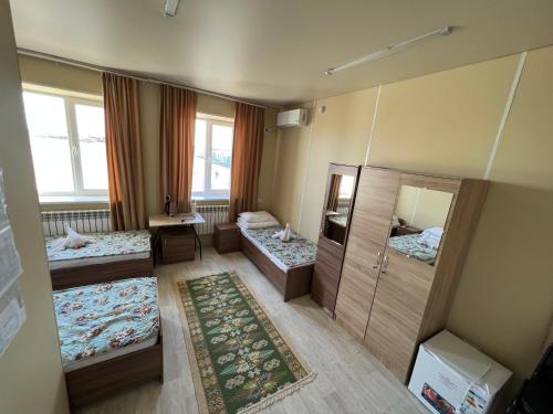 a room with three beds and a mirror at Bereke in Tengiz
