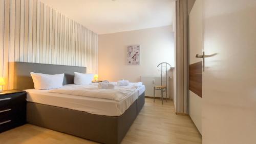 クックスハーフェンにあるStrandnahe Ferienwohnung Frische Brise 02.01のベッドルーム(白いシーツを使用した大型ベッド1台付)