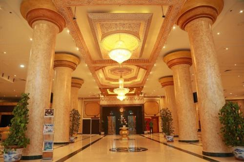 un hall d'un hôtel avec colonnes et plafond dans l'établissement Crown Palace Hotel, à Ajman