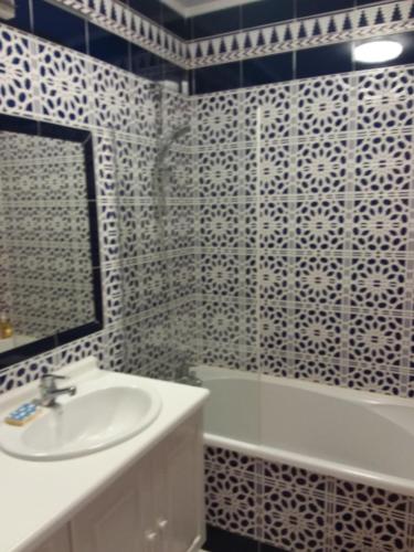ein Badezimmer mit einem Waschbecken, einer Badewanne und einem Spiegel in der Unterkunft Gite des artistes in Changy