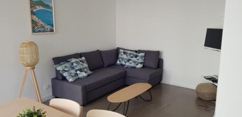 un salon avec un canapé bleu et une table dans l'établissement Les Pieds dans l'Ô - Appartement 50m2 Front de mer, à Saint-Cyr-sur-Mer