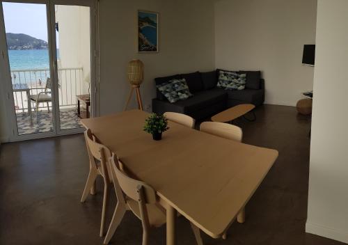 a living room with a table and chairs and a couch at Les Pieds dans l'Ô - Appartement 50m2 Front de mer in Saint-Cyr-sur-Mer