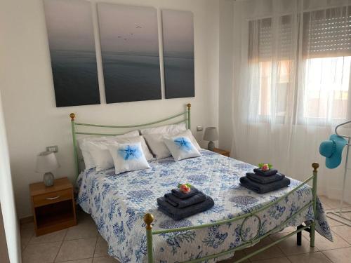 een slaapkamer met een bed met handdoeken erop bij Vento di Mare in Muravera
