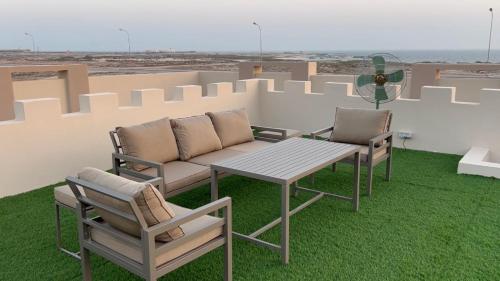 d'une terrasse sur le toit avec une table et des chaises. dans l'établissement Ocean Chalet, à Salalah