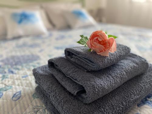 una pila de toallas con una rosa en la cama en Vento di Mare, en Muravera