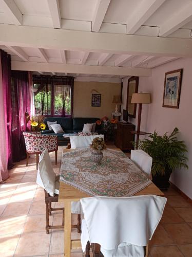 un soggiorno con tavolo e divano di Maison de tout vent a Pierrefonds