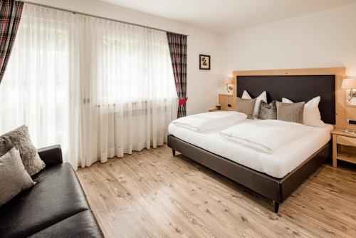 a bedroom with a large bed and a couch at Apartment Bellaria in Santa Cristina Gherdëina