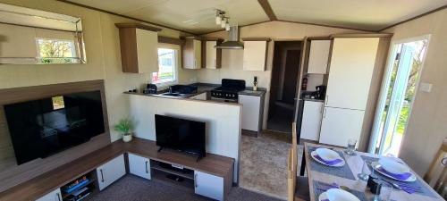 a living room with a tv and a kitchen at PK Holiday Home in Great Yarmouth