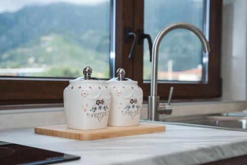 two mugs sitting on a cutting board next to a sink at Vincenzo Suites in Nydri