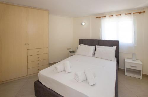1 dormitorio con 1 cama blanca grande con almohadas blancas en Rooftop apartment with great veranda, en Atenas