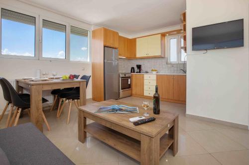 a living room with a table and a kitchen at Rooftop apartment with great veranda in Athens