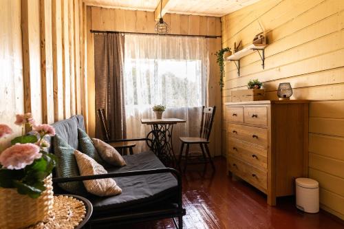 a living room with a couch and a table at Laivu māja Ezerkrasti in Alūksne