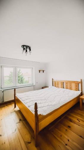 ein großes Bett in einem Zimmer mit Holzboden in der Unterkunft Noclegi Studio Masażu in Włodawa