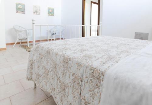 a bedroom with a bed with a white blanket on it at Mama Maja in Vacri