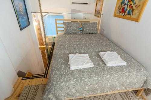 1 dormitorio pequeño con 1 cama con 2 toallas en City Passage Apartments, en Belgrado